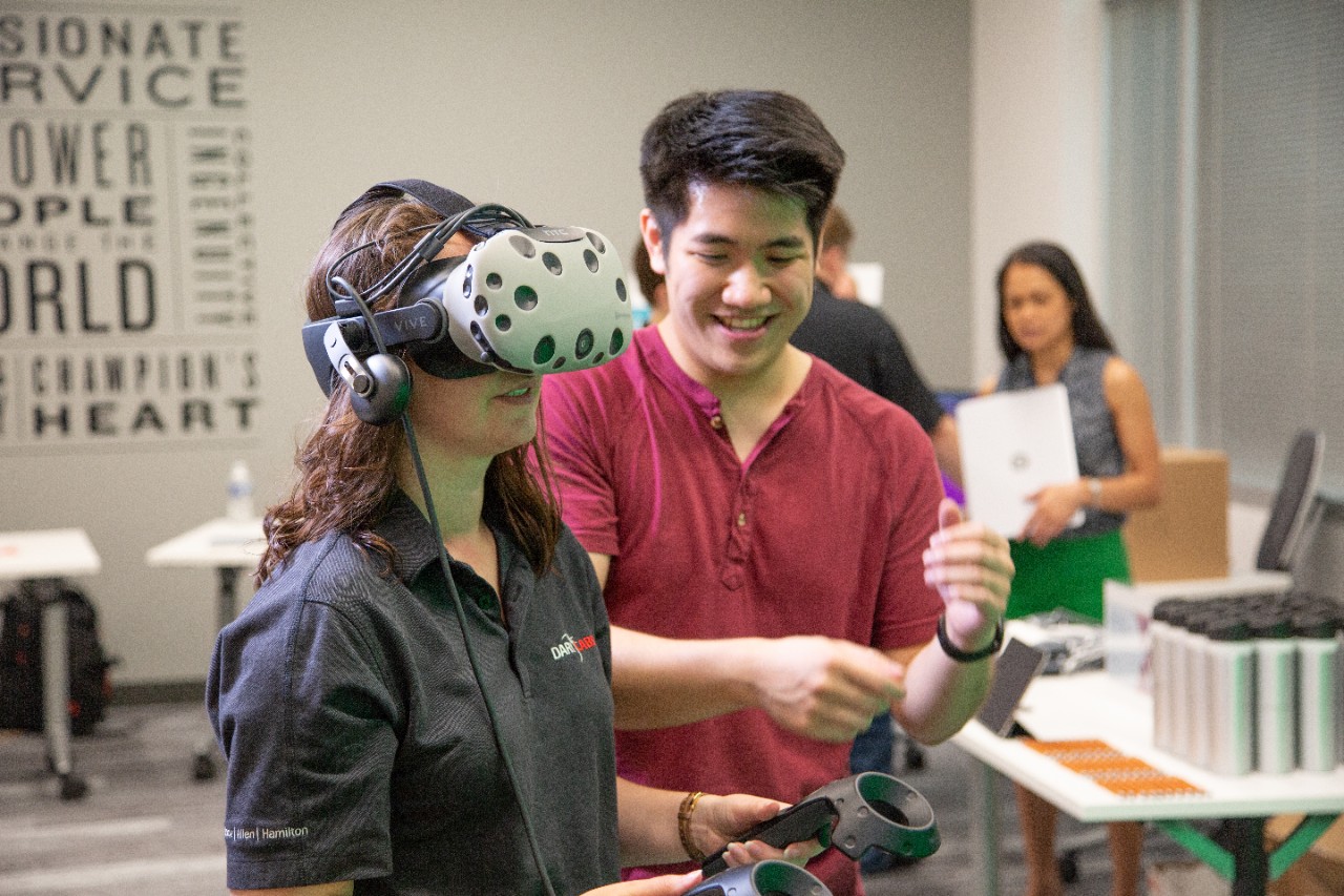 Man showing woman how to use artificial intelligence device