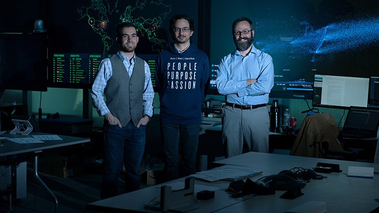 Three men standing in an office