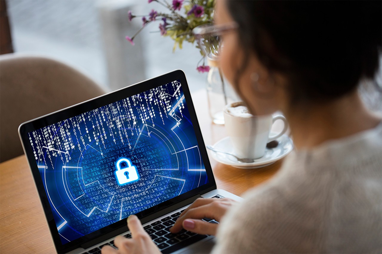 woman looking at her laptop screen wondering how to protect herself from malicious threats