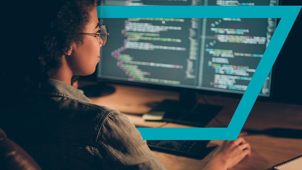 woman reviewing code on a computer monitor