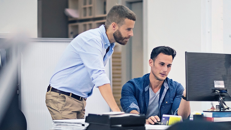 Two men looking at a computer.