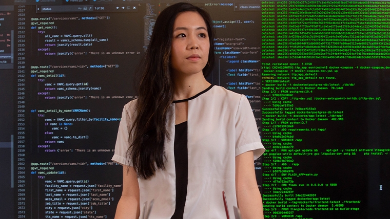 woman standing in front of large screen filled with analytics data